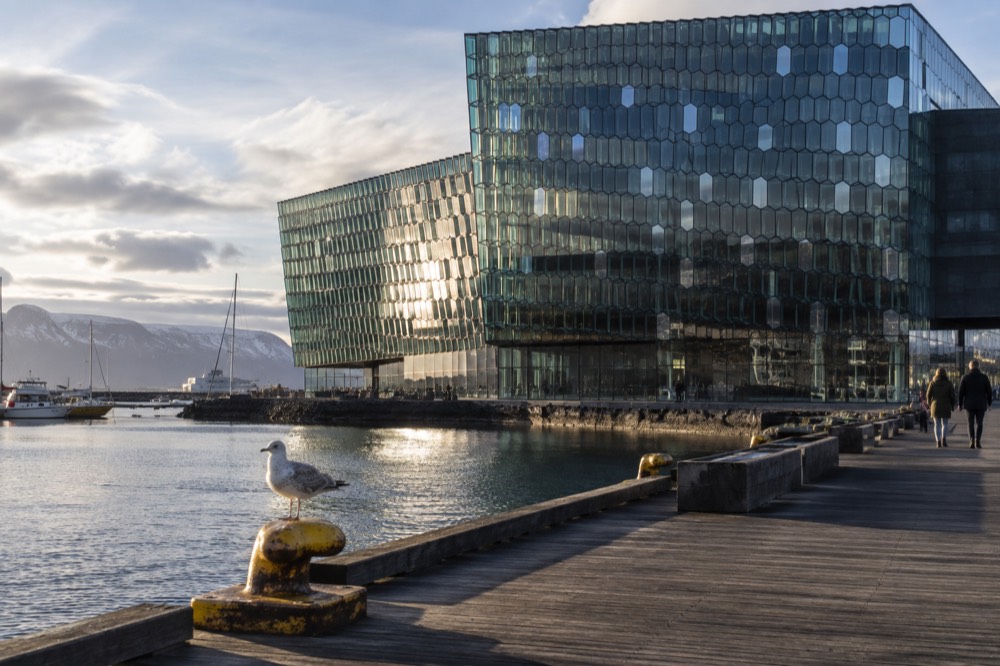 The glass facade of Harpa concert hall seen from the old harbour waterfront in daylight