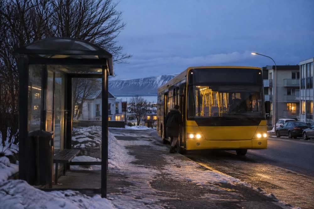A city bus at a stop on a quiet Reykjavik street