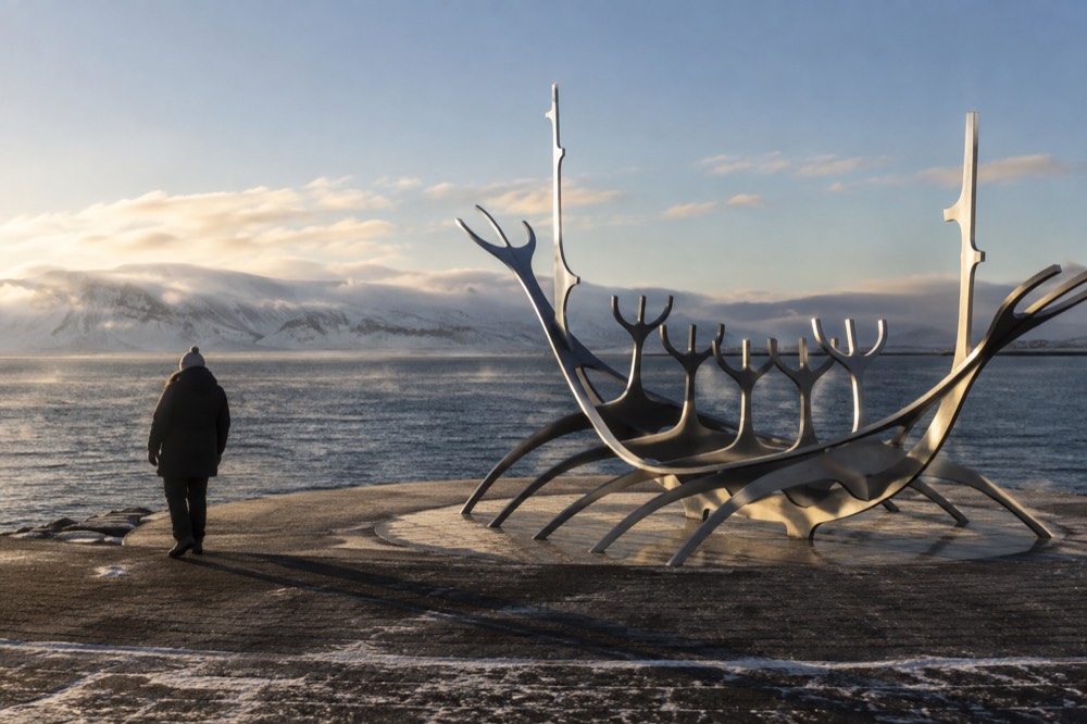Steel dream boat sculpture on the Reykjavik waterfront with mountains across the bay