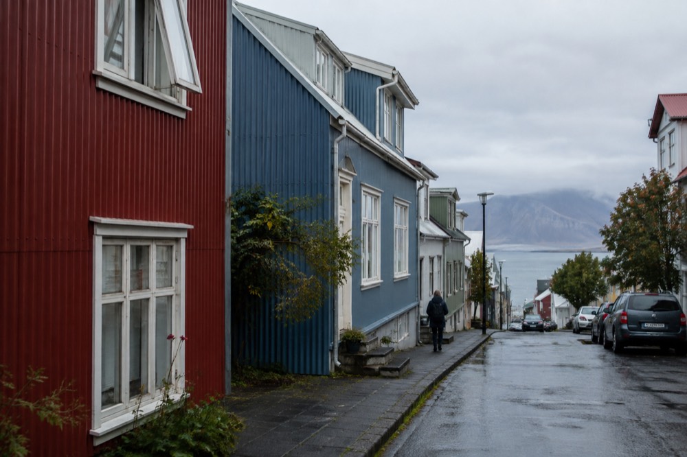 Colourful corrugated iron houses on a Reykjavik street with mountains behind