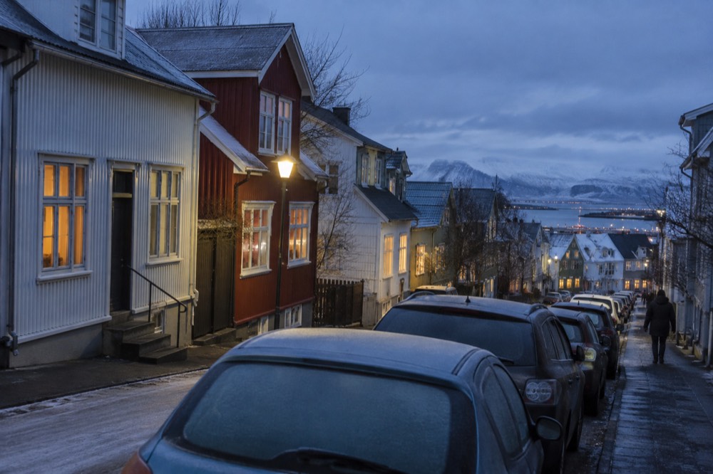 Row houses on a residential Reykjavik street with cars parked along the curb