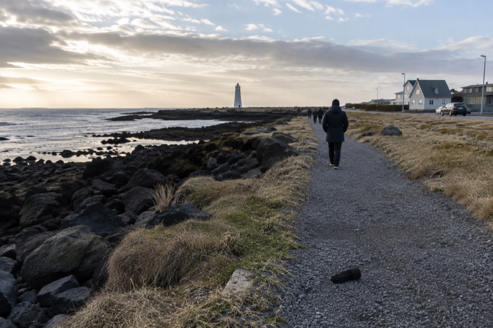 A coastal path on the Seltjarnarnes peninsula with a small lighthouse in the distance