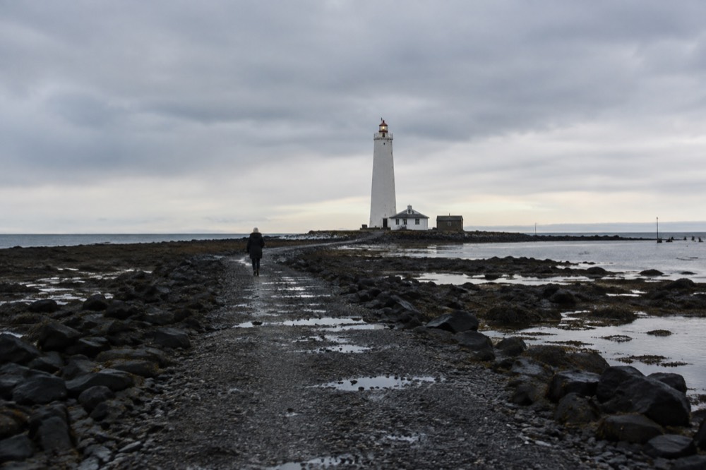 Grótta lighthouse at the end of a tidal causeway under a wide coastal sky