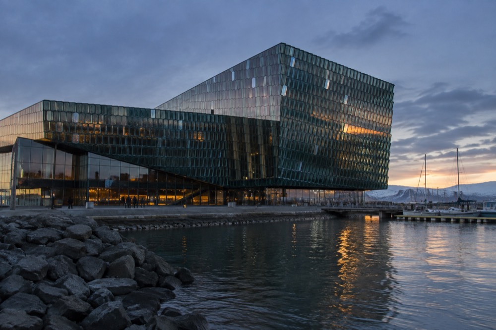 Geometric glass facade of Harpa concert hall reflecting evening light