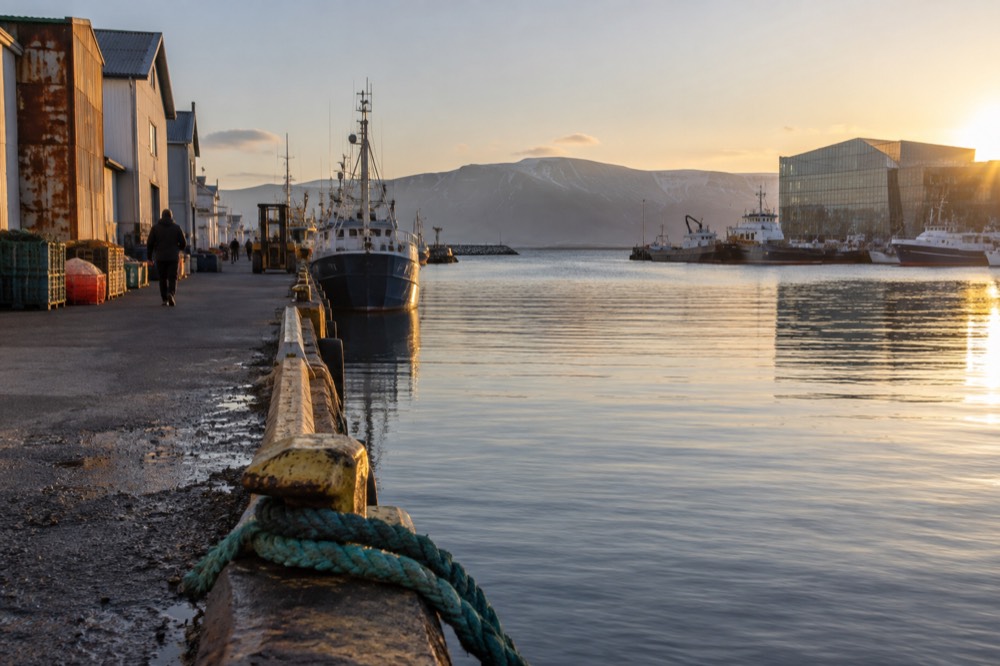 Reykjavik waterfront path at golden hour with mountains across the water