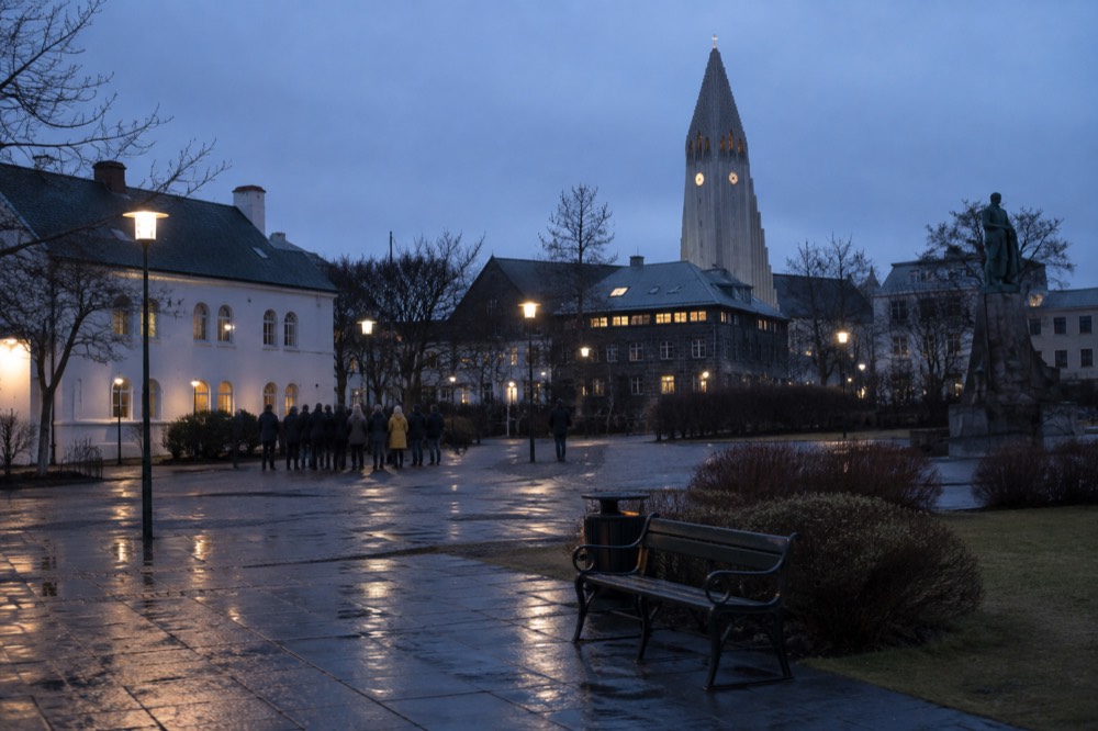 A guide speaking to a small group in a Reykjavik square with a stone church in the background