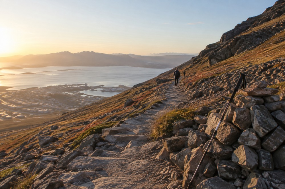 A marked hiking trail climbing a rocky mountain slope with the sea far below