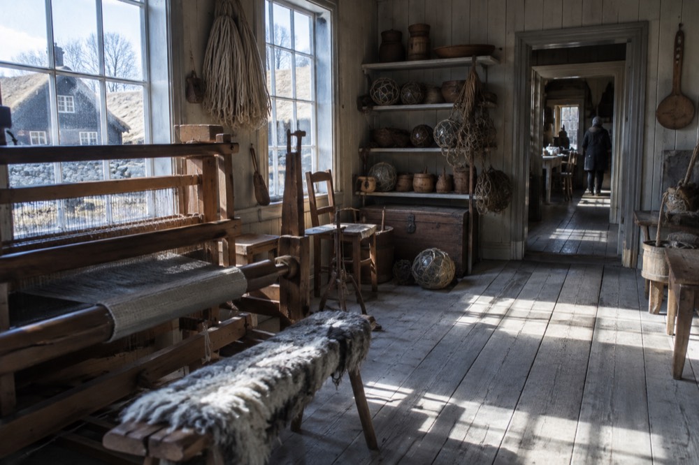 Interior of a small historic museum gallery with wooden artefacts on display