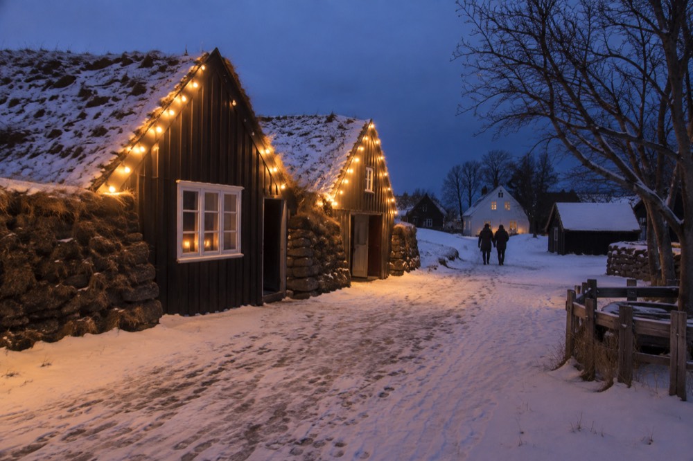 Museum buildings lit up at dusk with string lights along a pathway