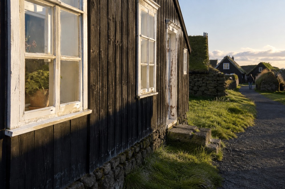 Historic timber farmhouse with black tarred walls and white window frames