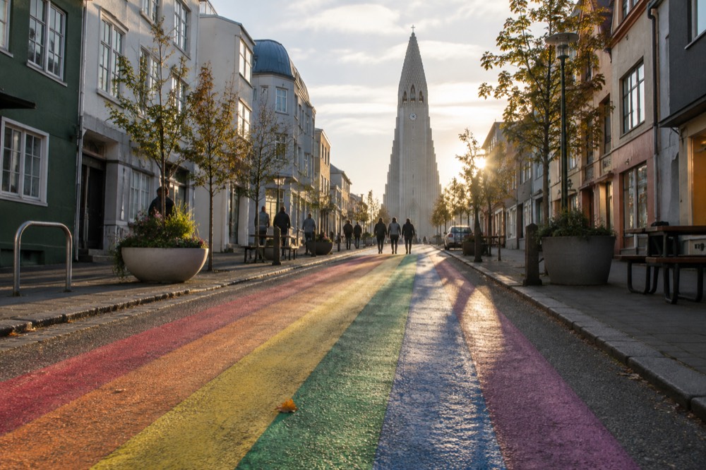 A rainbow painted street rising toward a large stone church