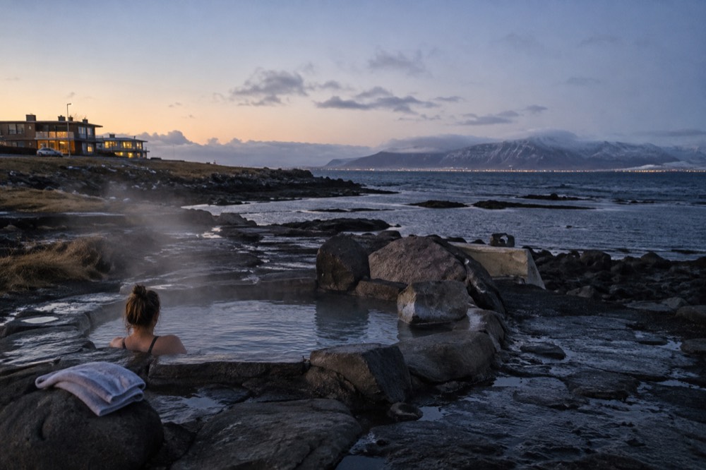 A stone foot bath on a coastal headland with ocean views at dusk