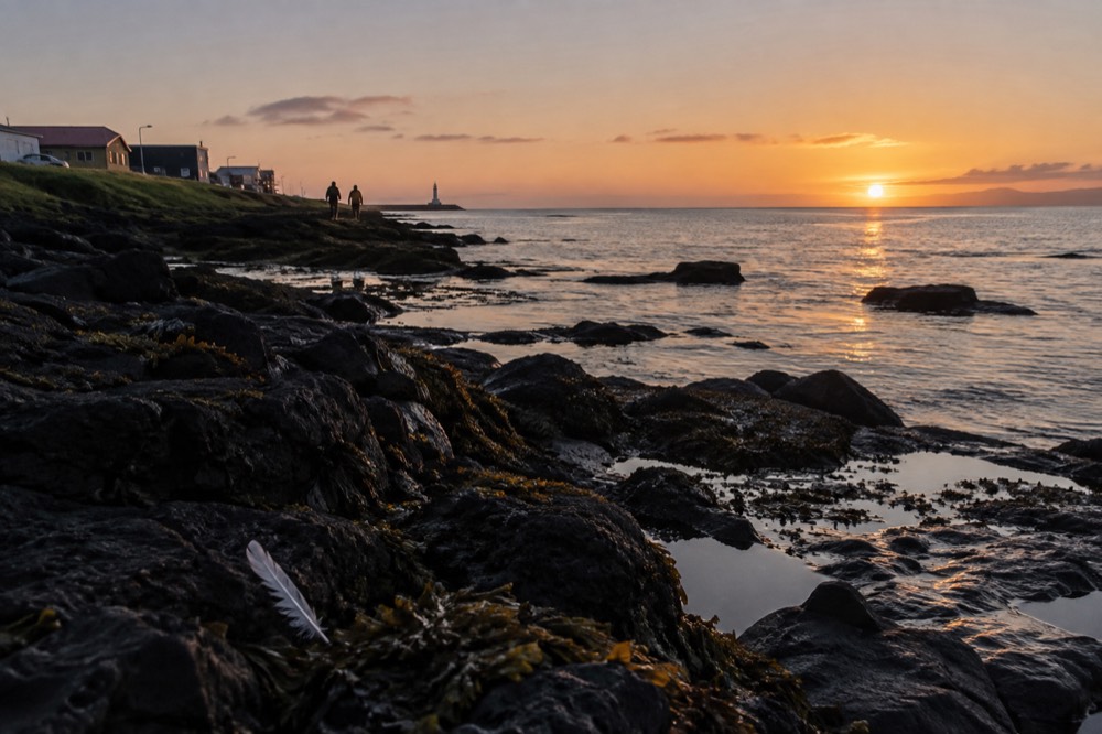 The sun sitting low over the sea horizon near Reykjavik late on a bright summer evening with calm water