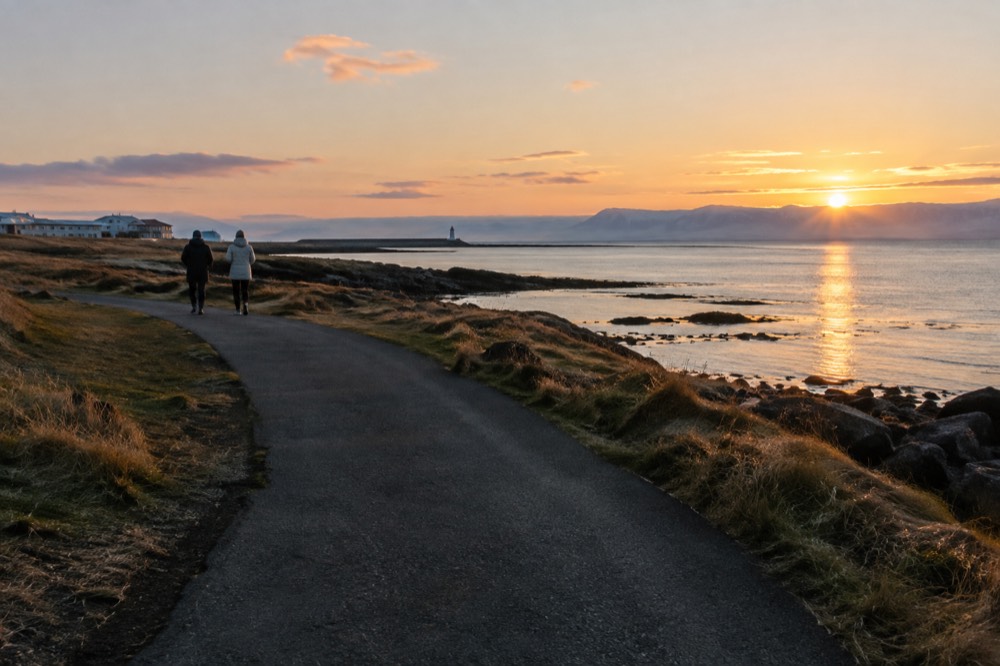 A long coastal walking path beside calm shallow water at golden hour