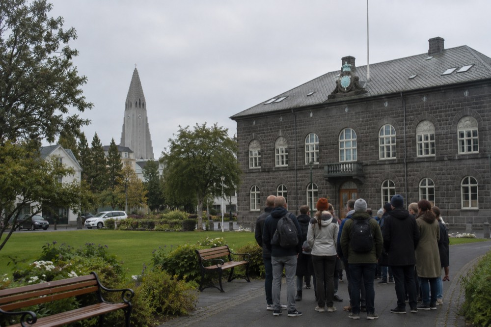 Walking tour group gathered on a Reykjavik square with the Hallgrímskirkja tower visible in the background