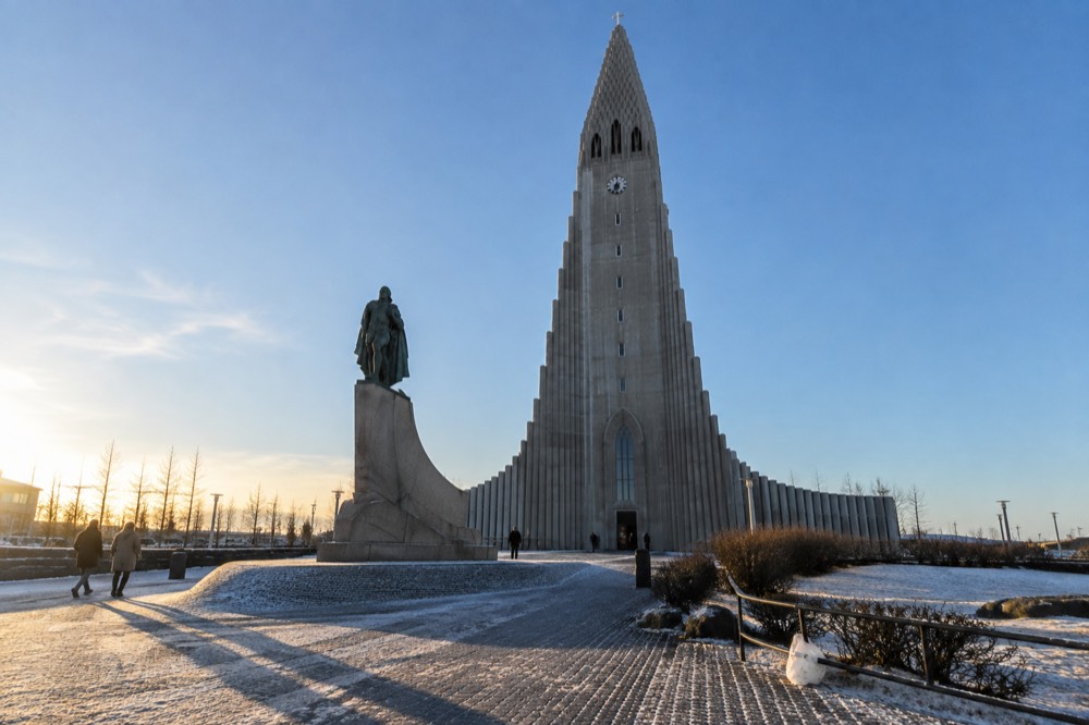 Hallgrímskirkja church tower and the statue of Leif Erikson in front, with blue sky