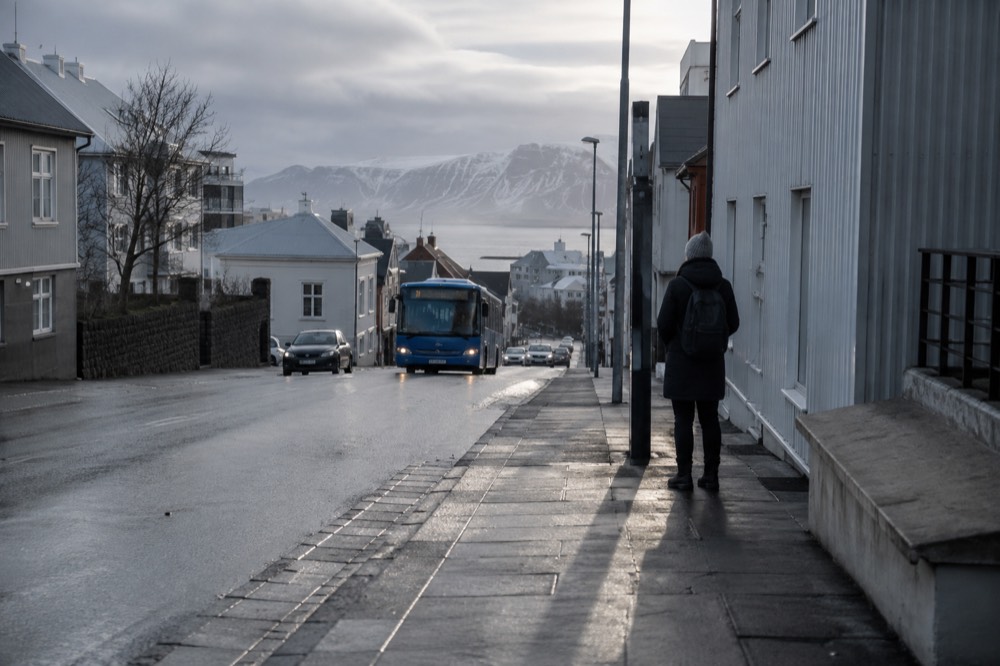 Blue city bus at a Reykjavik bus stop on a clear day