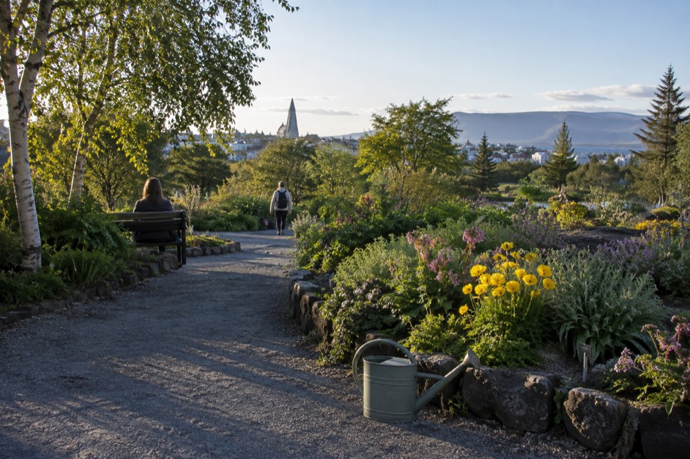 Flower beds and paths of the Reykjavik botanic garden in summer daylight