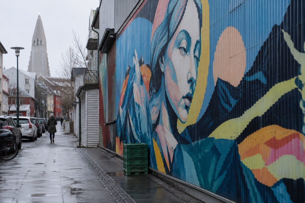Large colorful mural on a corrugated iron wall in a Reykjavik harbour street