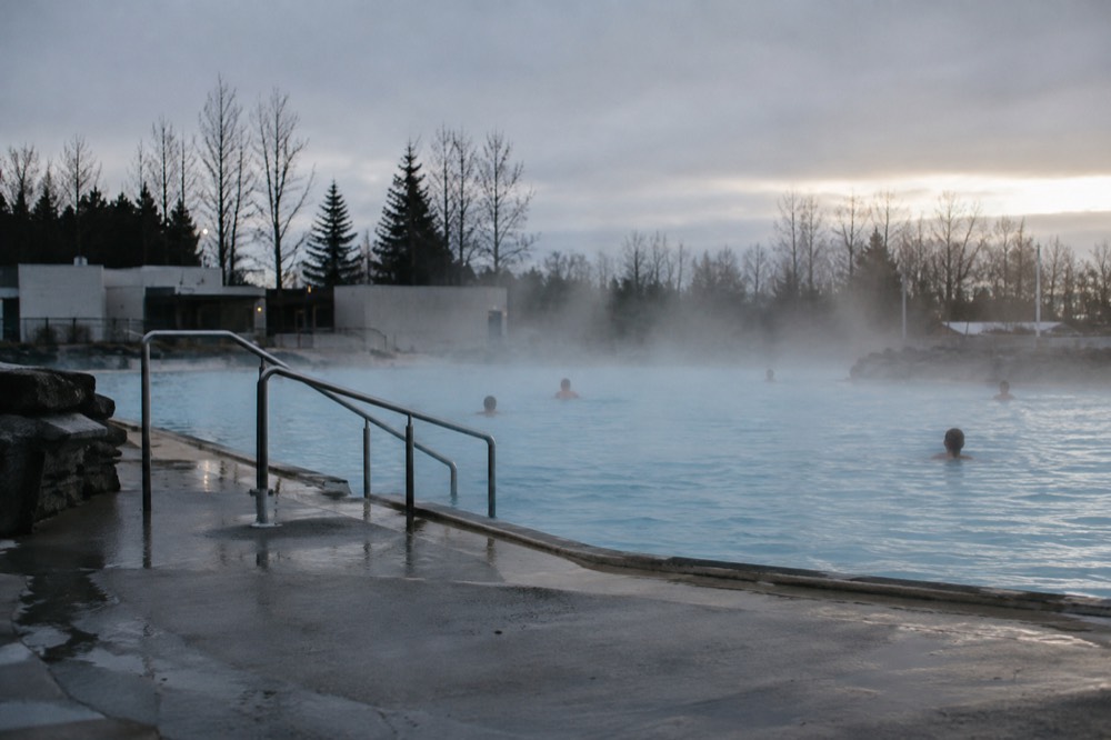Steam rising from an outdoor geothermal pool in cool weather