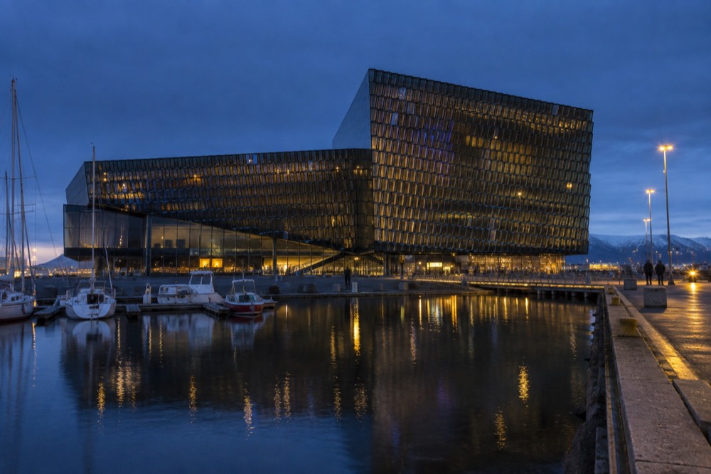 The geometric glass facade of Harpa concert hall seen from the harbour side