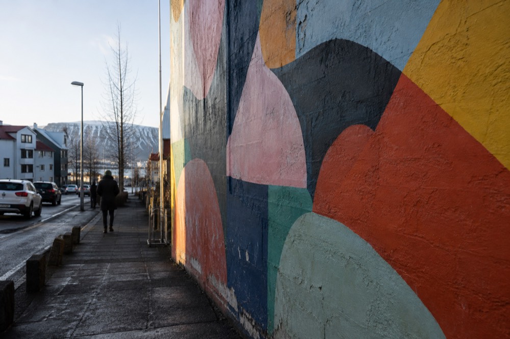 A detailed close view of a painted mural showing abstract shapes in bright colors on a concrete wall