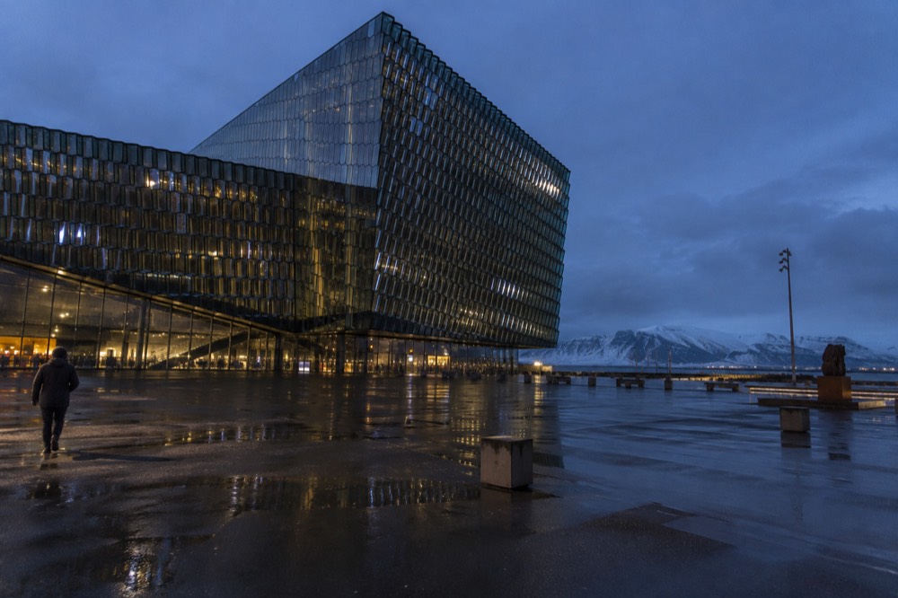 The patterned glass facade of a large concert hall building by the waterfront in Reykjavik