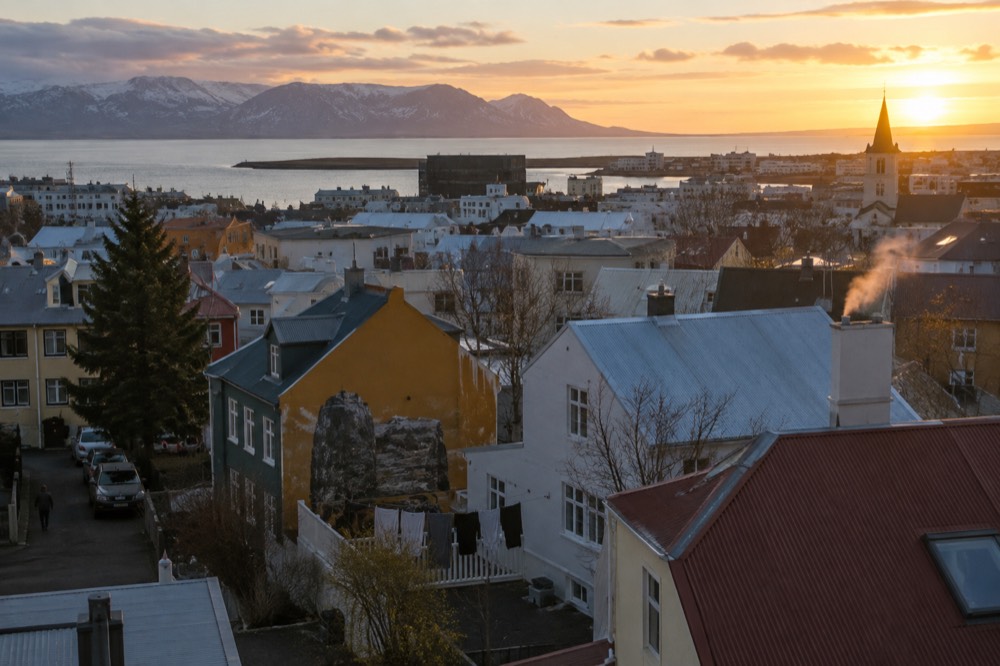 A wide view over Reykjavik rooftops with painted building walls visible among the houses