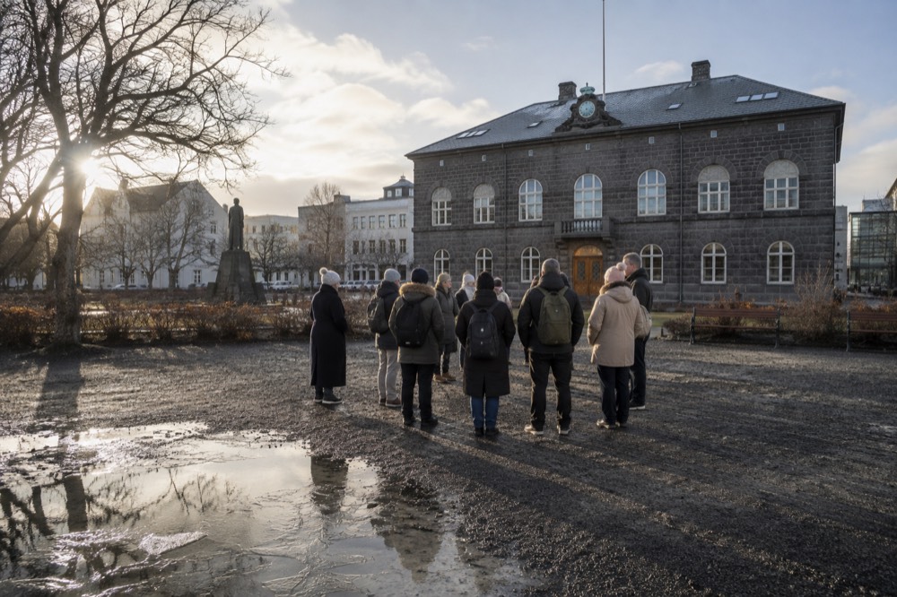 A guide speaking to a small group in an Icelandic city square
